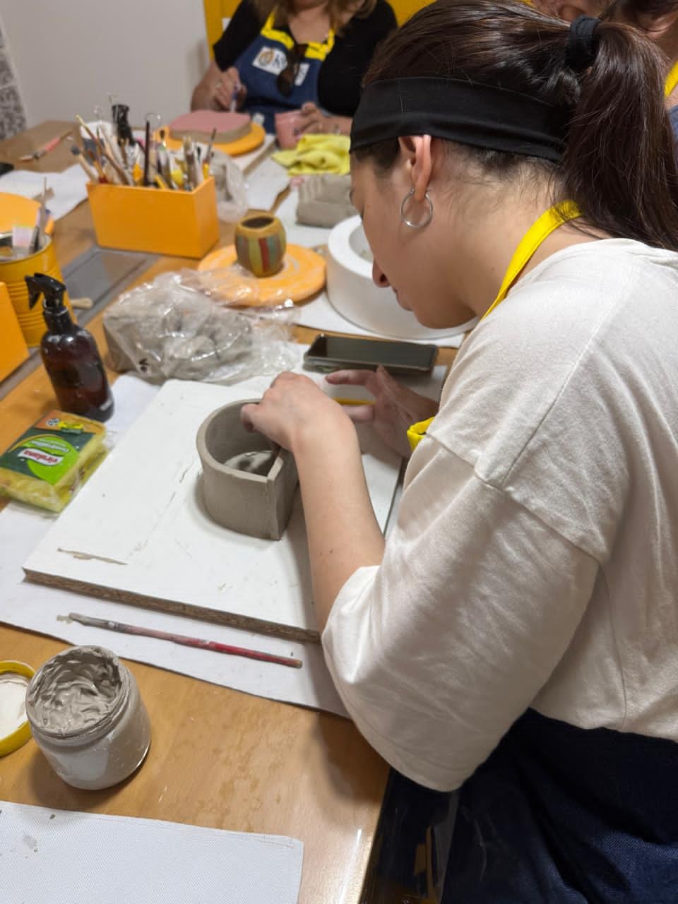 mujer joven haciendo pieza de ceramica