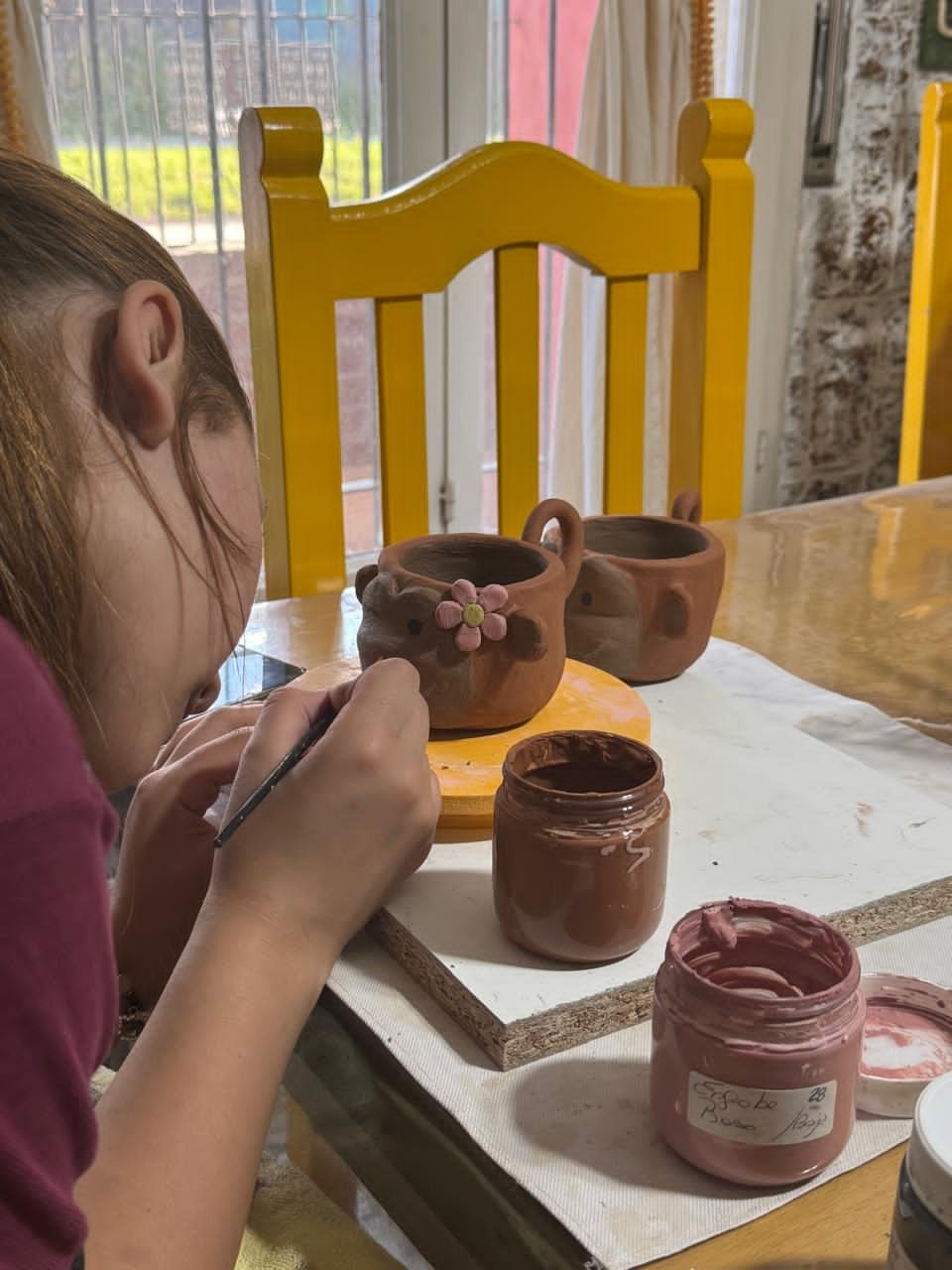 niña pintando ceramica