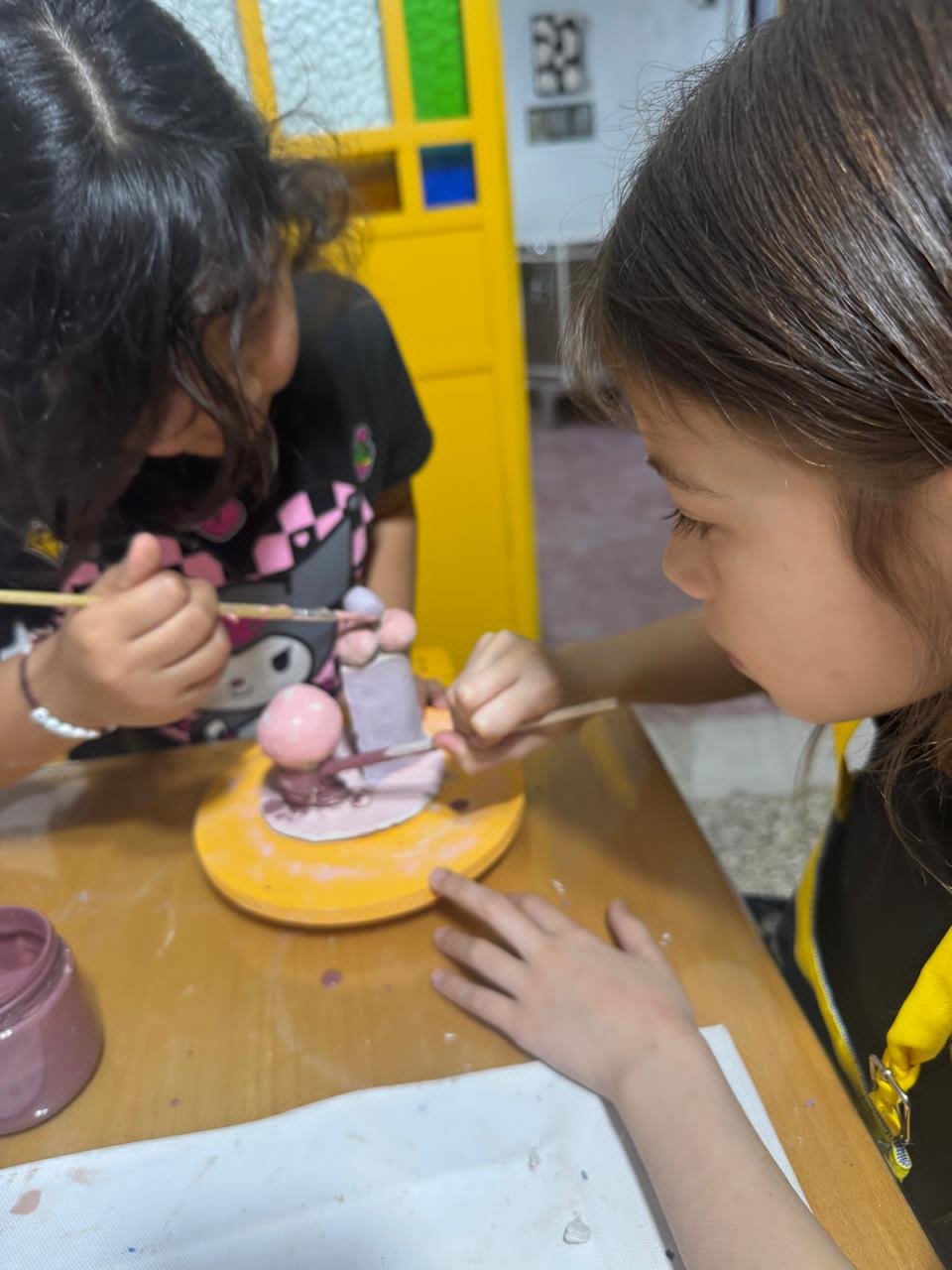 dos niñas pintando ceramica